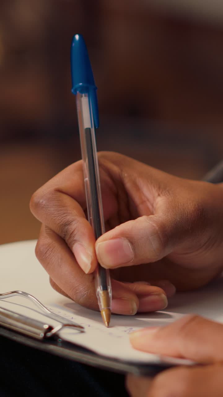 Vertical video: Male psychologist writing notes at consultation with person