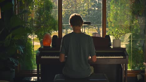 Junge-Spielt-Klavier-An-Einem-Fenster---Totale