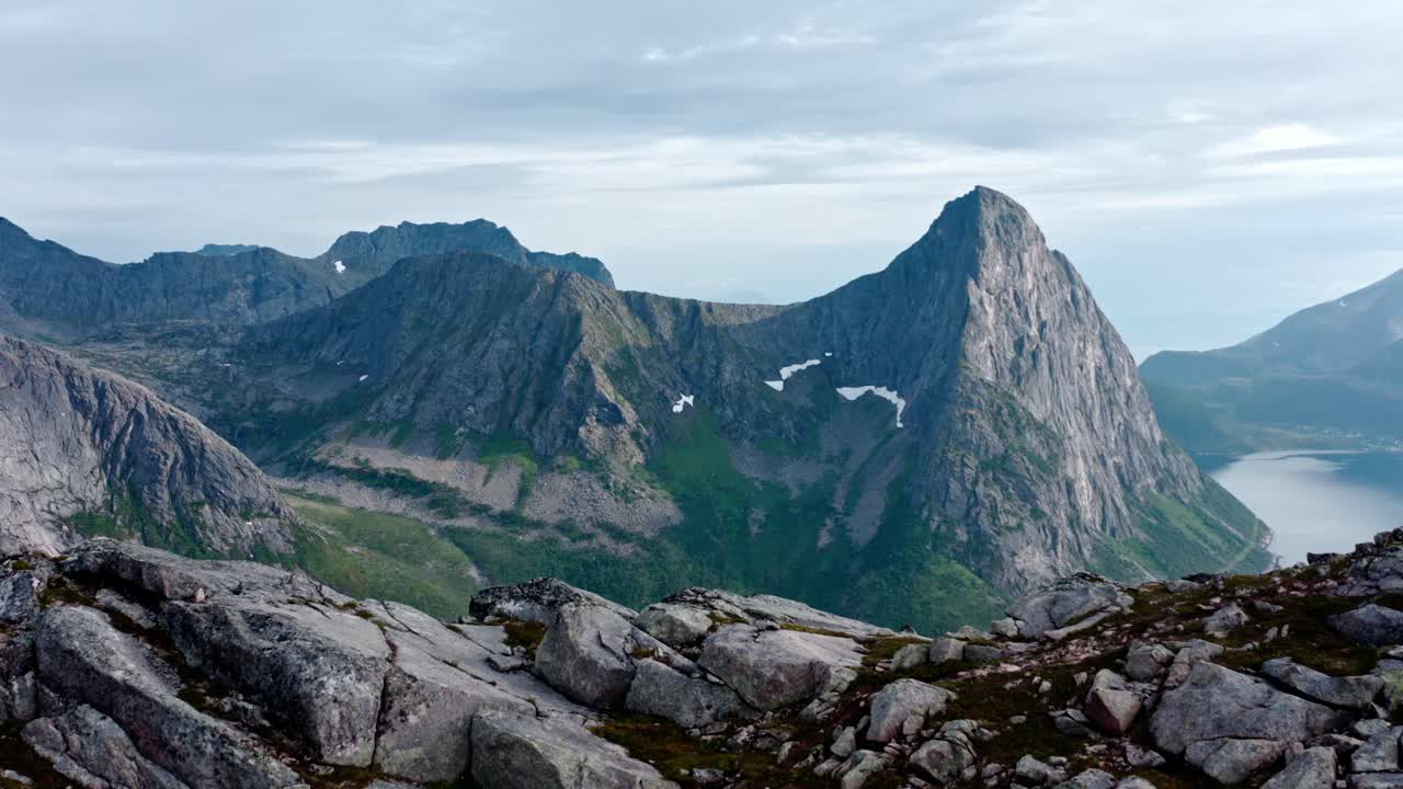 Luftfoto av fjelltoppen Salberget og fjord med stille vann i Flakstadvåg, Norge