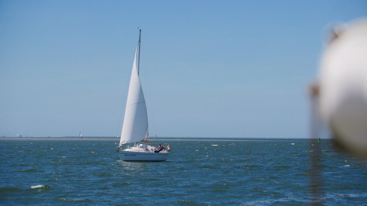 un velero blanco navegando en mar abierto con una bandera holandesa en cámara lenta