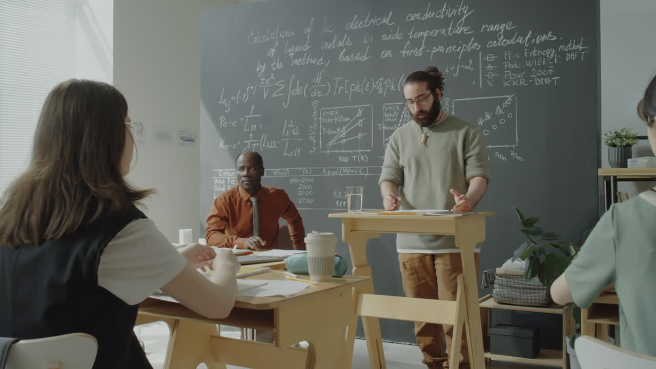 Professor lecturing students on electrical conductivity in a classroom