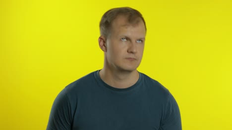 portrait of young caucasian man posing in green t-shirt. funny handsome guy shakes his head, smiling