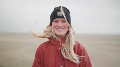 blonde caucasian girl smiling with wind blown hair - medium shot