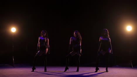 three women performing a stage dance