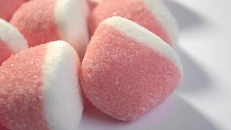 dulces de mermelada de azúcar rosa sobre fondo blanco. dulces de gelatina caramelizados rojos. macro