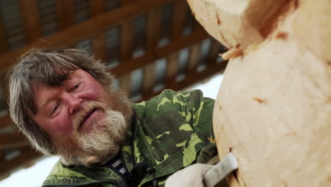 elderly wood carver working on sculpture