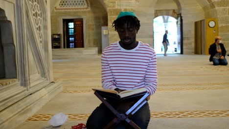 Hombre-Africano-Musulmán-Leyendo-El-Corán-En-La-Mezquita