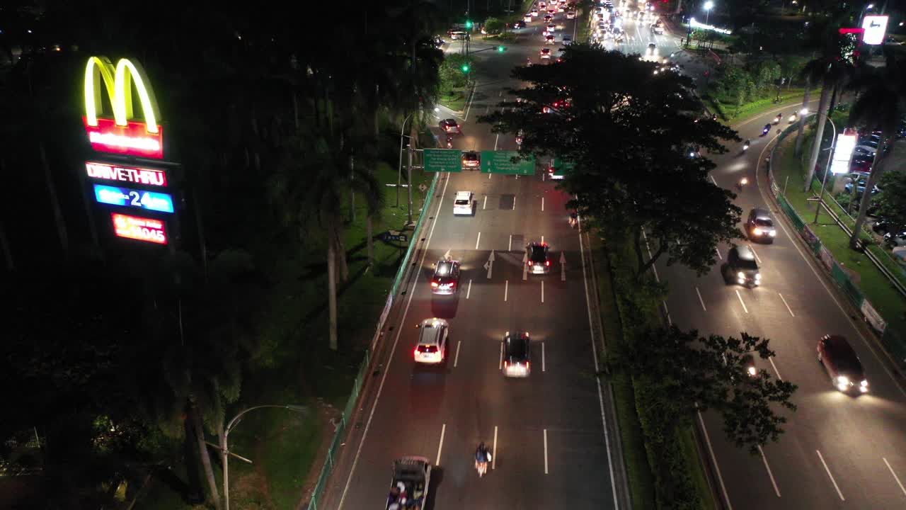 tráfico nocturno en una ciudad con mcdonald's drive-thru