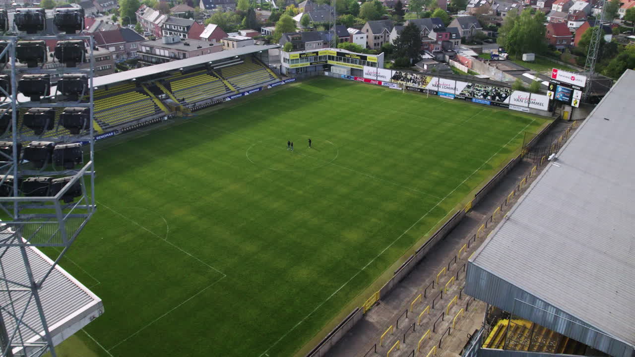 drone dolley tiro inclinado de un mástil de luz junto a un estadio de fútbol en europa