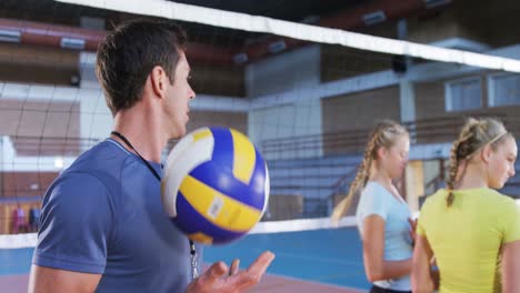 entrenador masculino de pie con voleibol en la cancha 4k