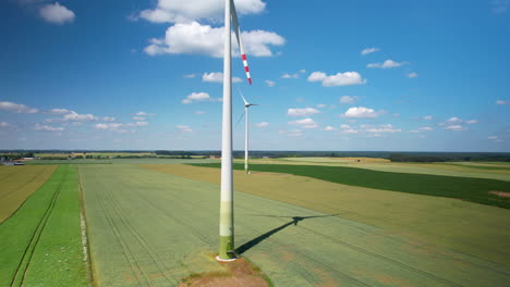 Die-Aufnahme-Eines-Drohnen-Risers-Zeigt-Rotierende-Rotorblätter-Von-Windkraftanlagen-Auf-Ackerland