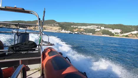 la vista desde la parte trasera de una lancha rápida con la costa en el horizonte