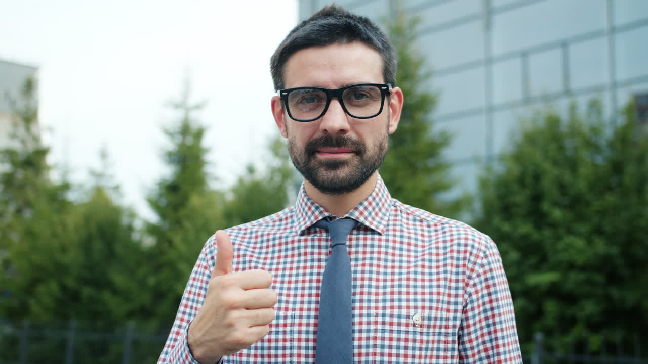 Businessman giving thumbs up in urban setting