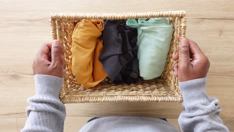 person holding a basket of folded clothes