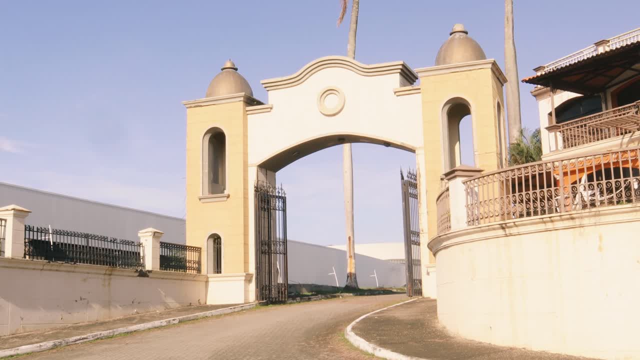 tiro inclinado hacia abajo desde altas y hermosas palmeras frondosas hasta las puertas del acceso vehicular del centro de convenciones amador de la ciudad de panamá durante una mañana cálida y brillante con cielos azules claros en el trópico