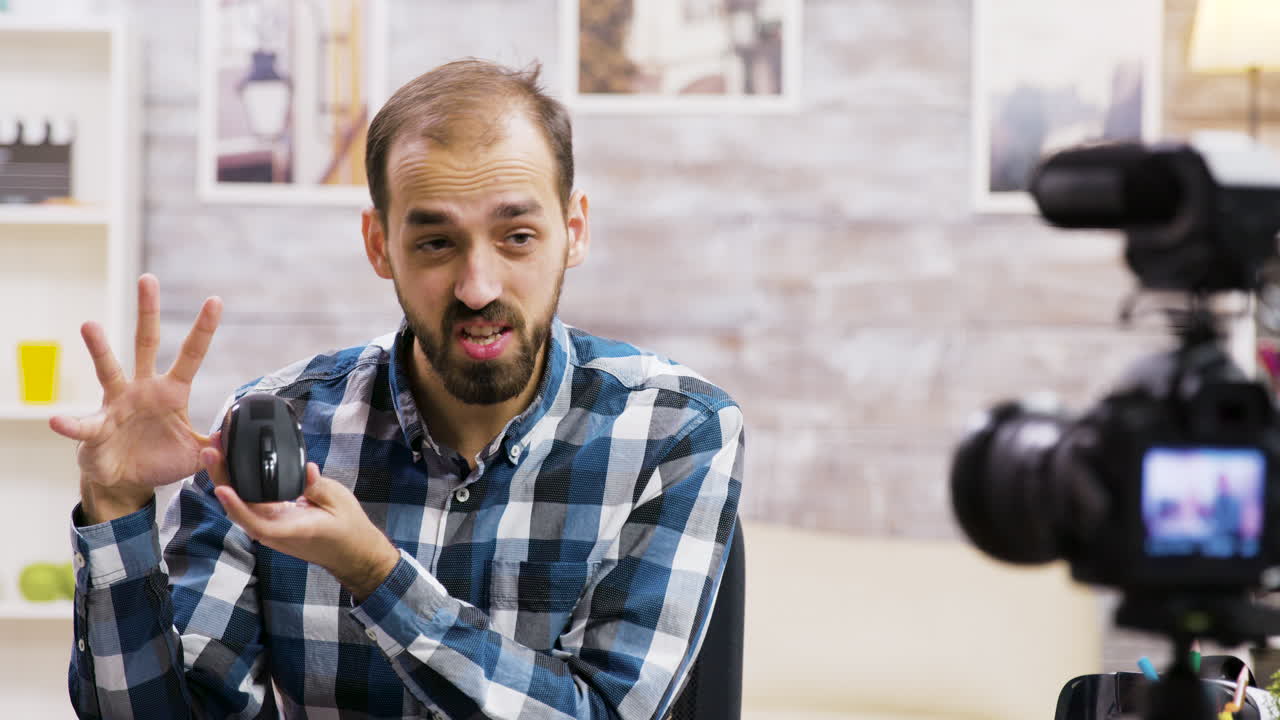 Uomo che recensisce un mouse per computer sul suo vlog