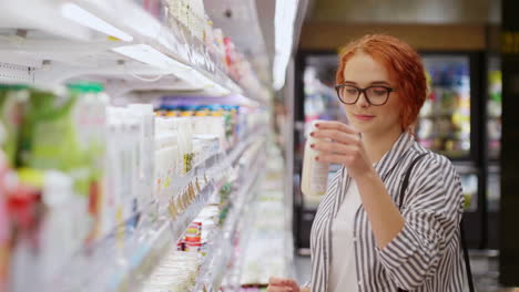 Mujer-Joven-Caucásica-Eligiendo-Productos-Lácteos-En-Un-Supermercado.