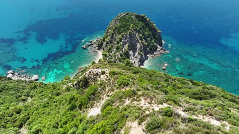 Sonnenbeschienene-Klippen-Auf-Der-Insel-Korfu-Mit-üppigem-Grün-Und-Dem-Ionischen-Meer,-Luftaufnahme