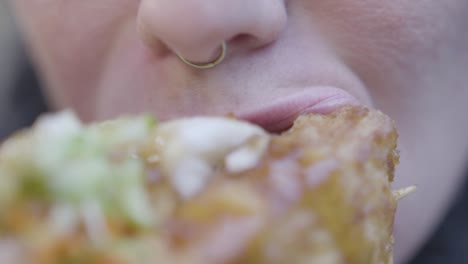 close up slow motion of woman with nose ring eating stinky tofu with vegetables in taiwan