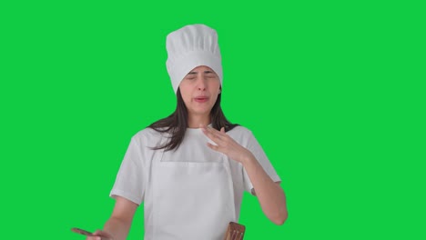 una chef profesional india está degustando comida picante en pantalla verde.