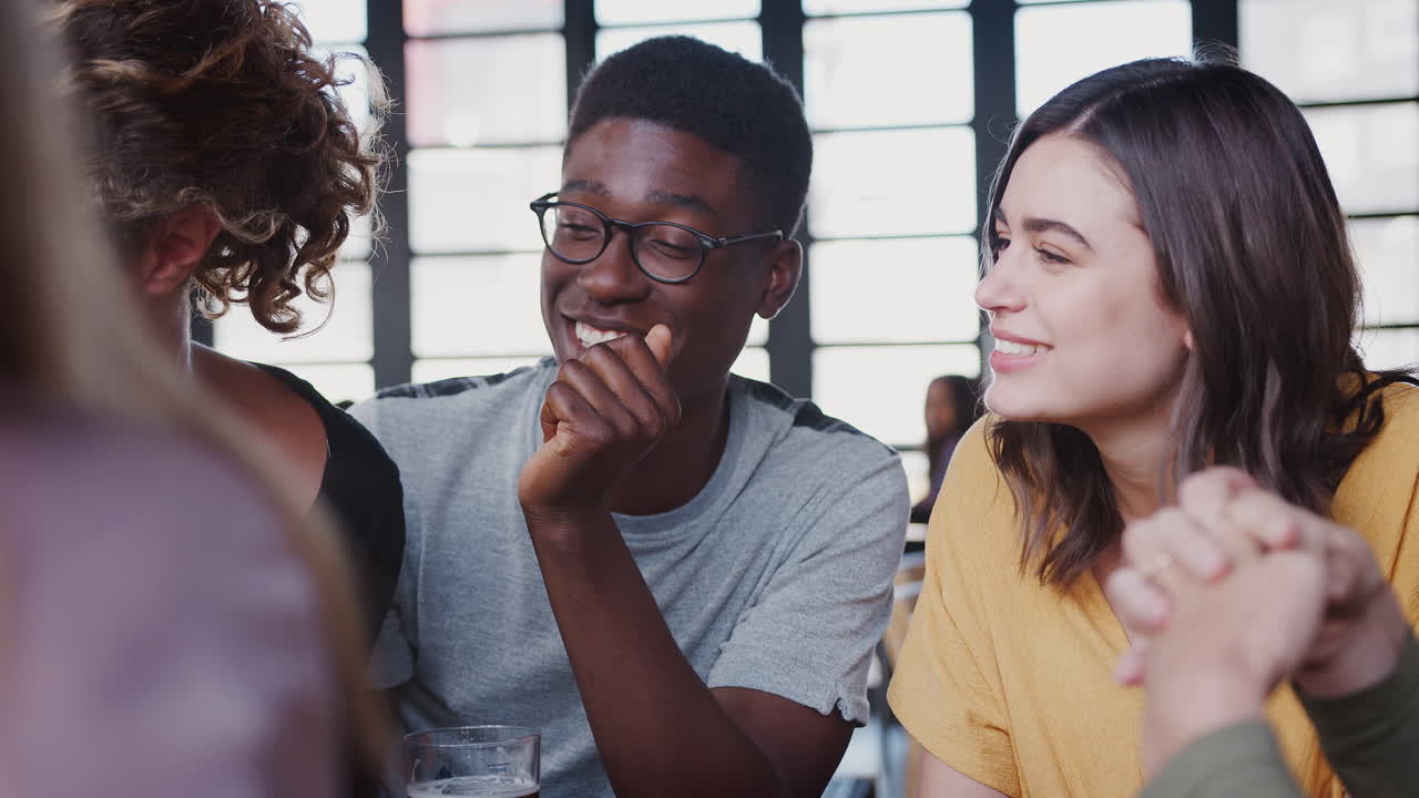 grupo de jóvenes amigos que se reúnen para tomar una copa y socializar en un bar