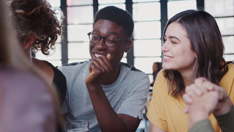 grupo de jóvenes amigos que se reúnen para tomar una copa y socializar en un bar