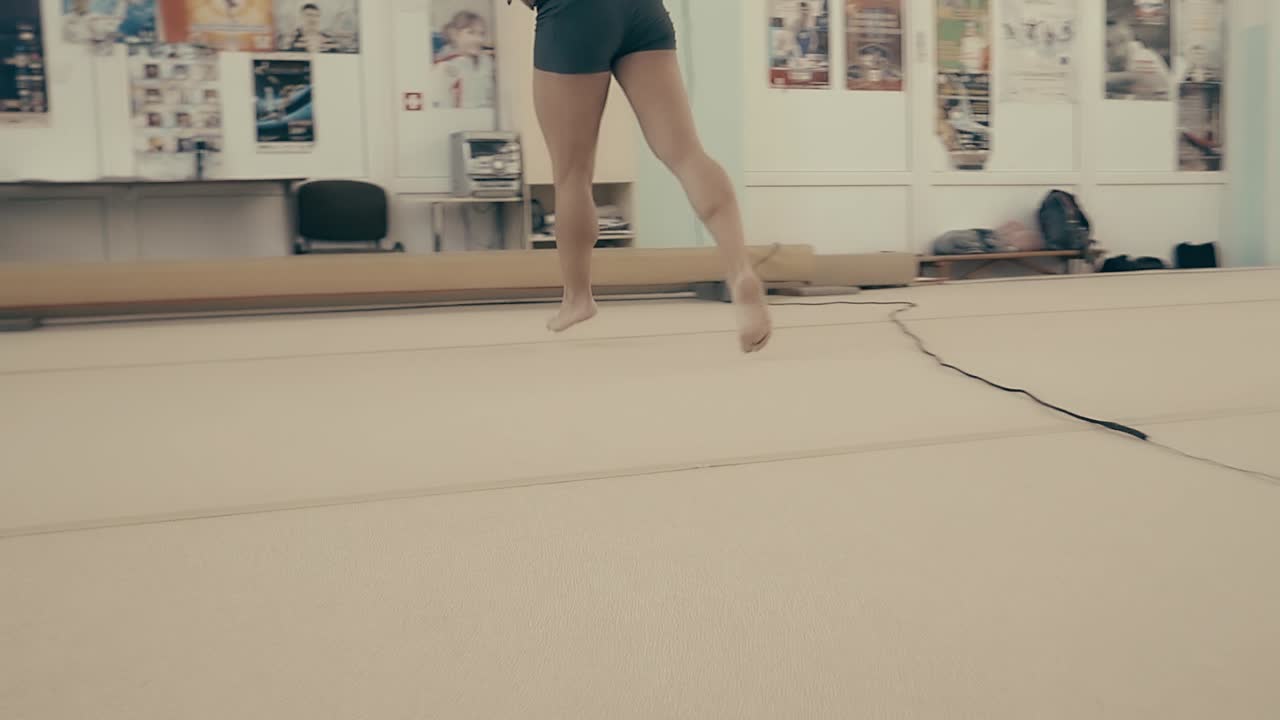 chica atlética en el gimnasio corriendo en círculos haciendo calentamiento antes de entrenar de cerca