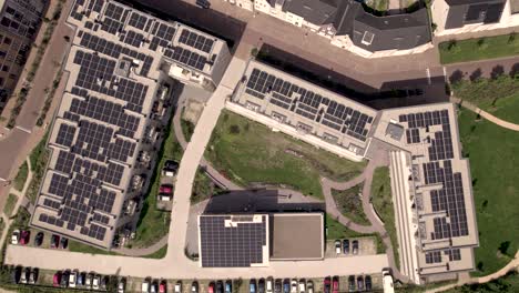 Descenso-Aéreo-De-Arriba-Hacia-Abajo-Que-Muestra-Los-Tejados-Llenos-De-Paneles-Solares-En-El-Edificio-Colectivo-Del-Complejo-Residencial-De-Viviendas-Sociales-En-Zutphen,-Países-Bajos