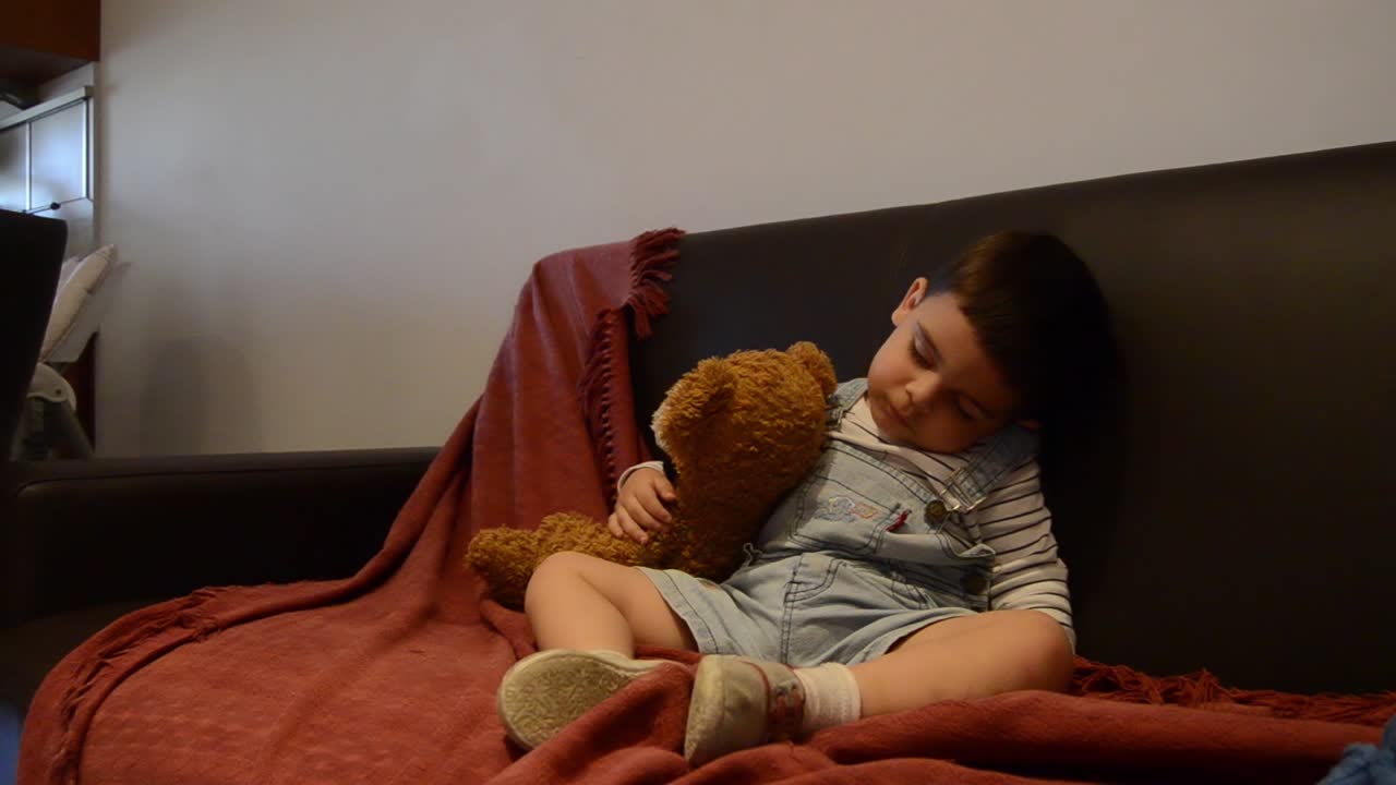 귀여운 피곤한 유아가 소파에서 잠이 들었습니다 - 재미있는 아기 얼굴 표정