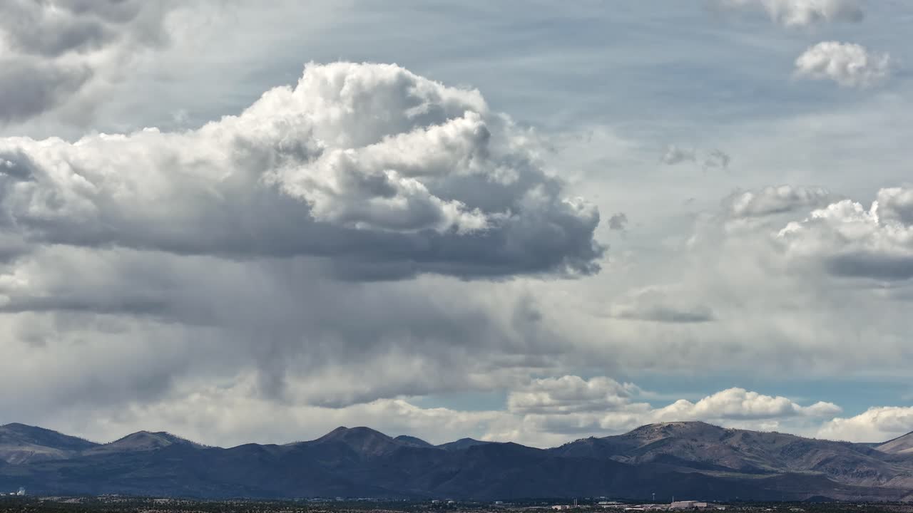 A dramatic 4K drone hyperlapse captures monsoon storm clouds forming and shifting over a southwest mountain peak. The rapid cloud motion and turbulent weather create a powerful cinematic background