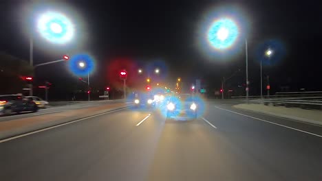 Nach-Hinten-Gerichteter-Nachtfahrpunkt-Pov-Für-Innenraum-Autoszene-Greenscreen-Ersatz---Feierabendverkehr-Auf-Einer-Zweispurigen-Vorstadtstraße-Und-Ausfahrt-In-Eine-Dunkle-Straße