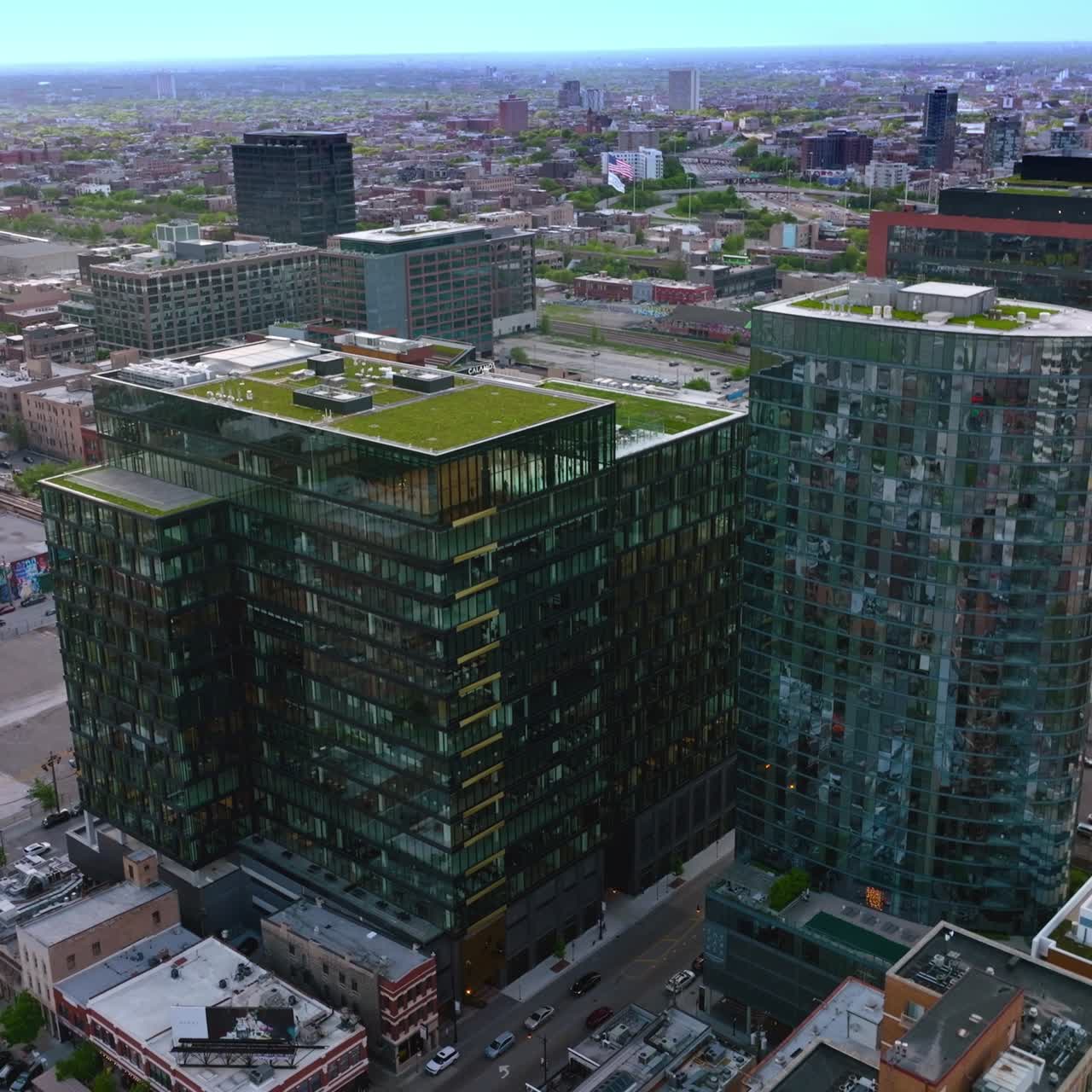 Modern mirror buildings with green grass lawn on the roofs. Panorama of stunning vibrant Chicago at daytime. Top view