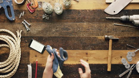 top view artisan craftsman hands using smartphone touchscreen viewing building plans from above - red epic dragon