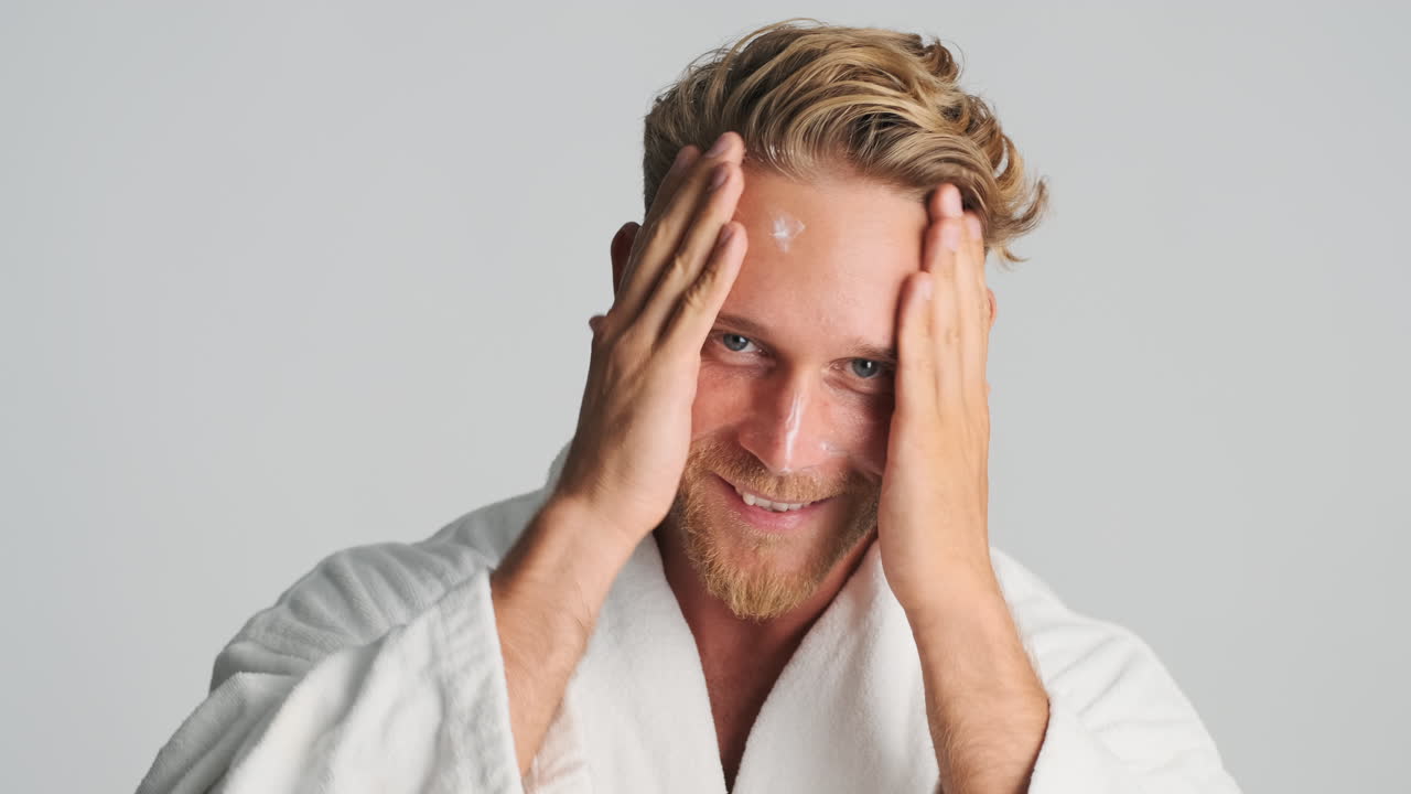 얼굴 에 로션 을 바르는 행복 한 사람