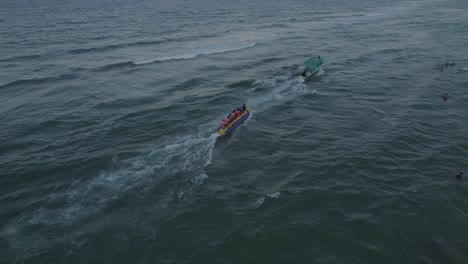 gente montando un bote banana en el mar