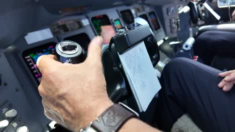 vista de cerca de la mano izquierda de un piloto que maneja la rueda de control de un jet moderno