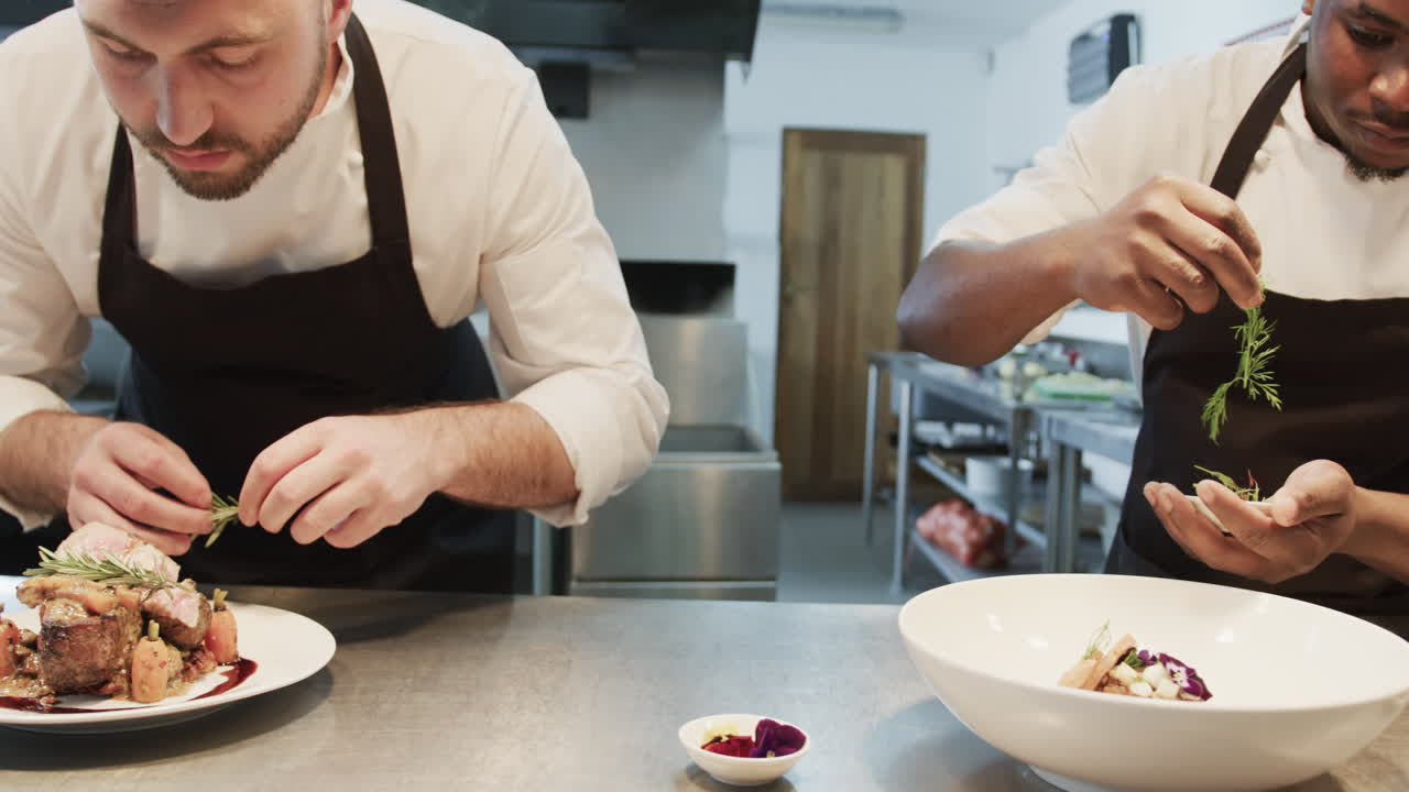 dos cocineros varones diversos decorando las comidas en la cocina, en cámara lenta