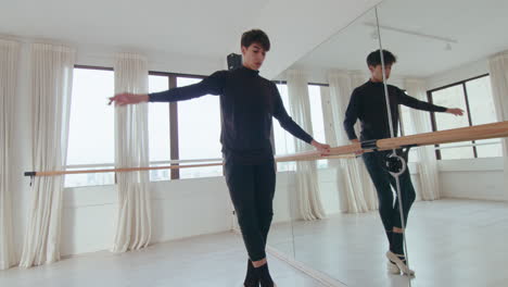 Male Ballet Dancer Exercising at the Barre in Studio
