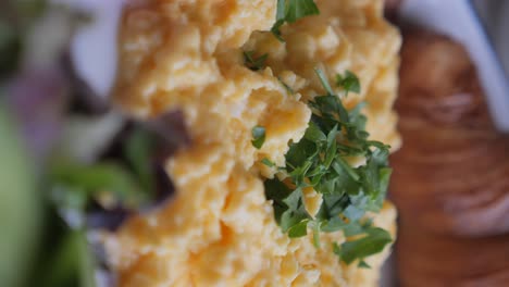 close-up of scrambled eggs topped with fresh herbs