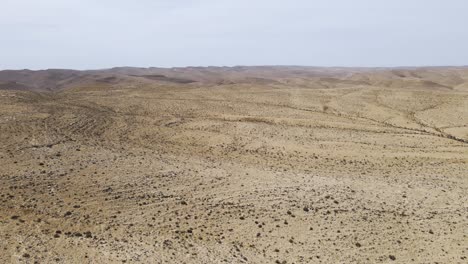 Endless-wild-desert-landscape-on-a-sunny-day-with-blue-sky-at-Ramon-Crater-in-the-Negev-Desert,-Israel---aerial