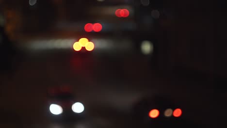 driving ambulance flashing lights on street full of cars at night, soft focus view
