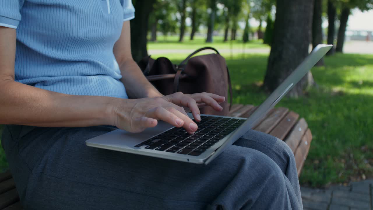 Woman working on a laptop in the park