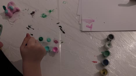 creative play with paint. a child paints with paints on the table