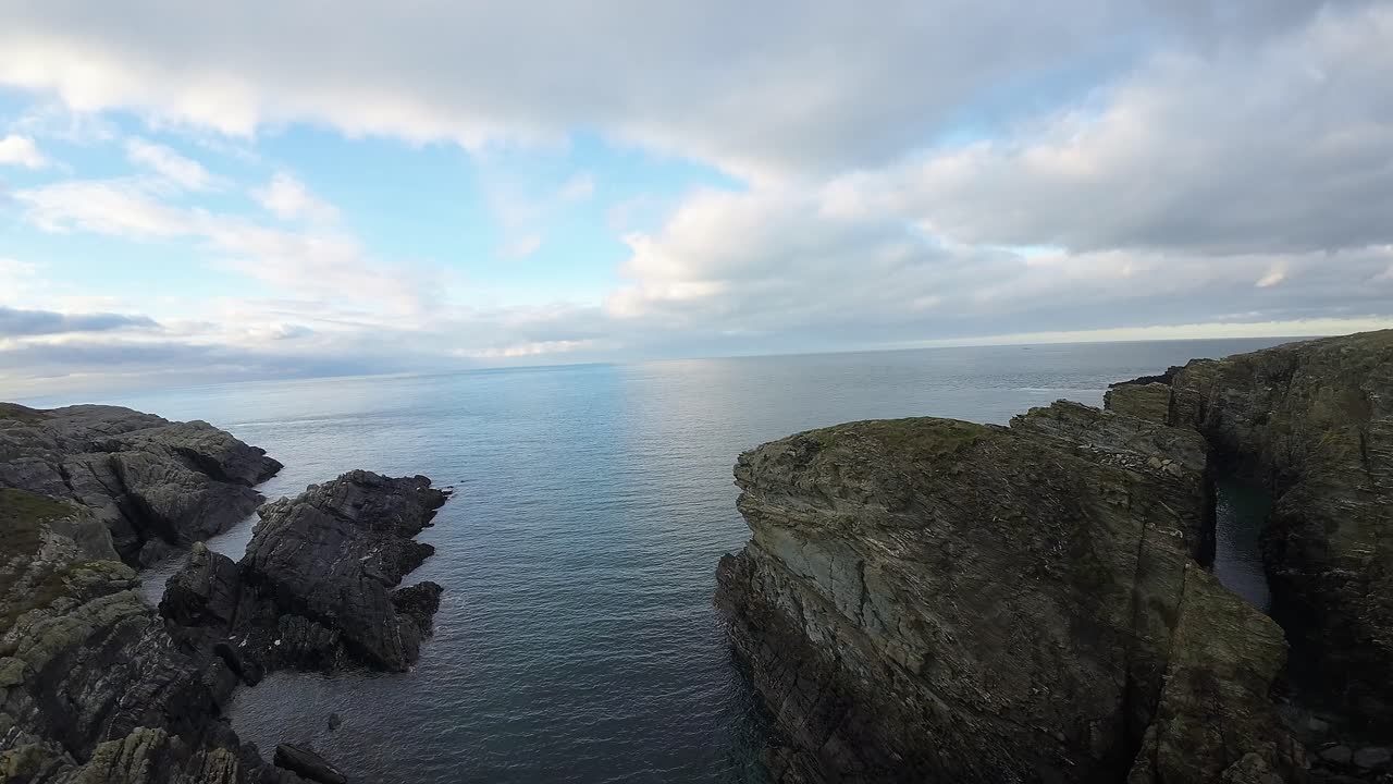 Penerbangan udara FPV dinamis di atas tebing pantai laut Welsh yang terjal dan lanskap tanjung