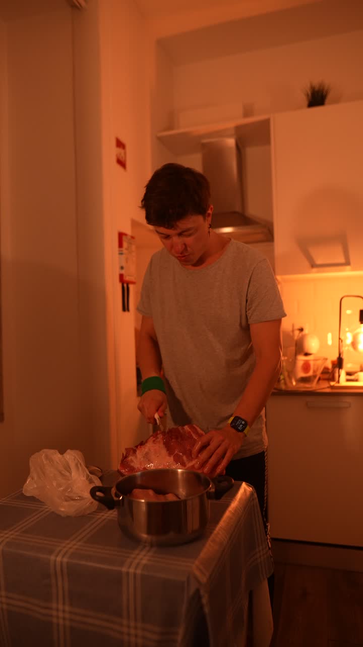 persona preparando carne de cerdo en una cocina.