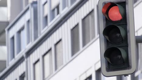a red traffic light is sitting in front of a building