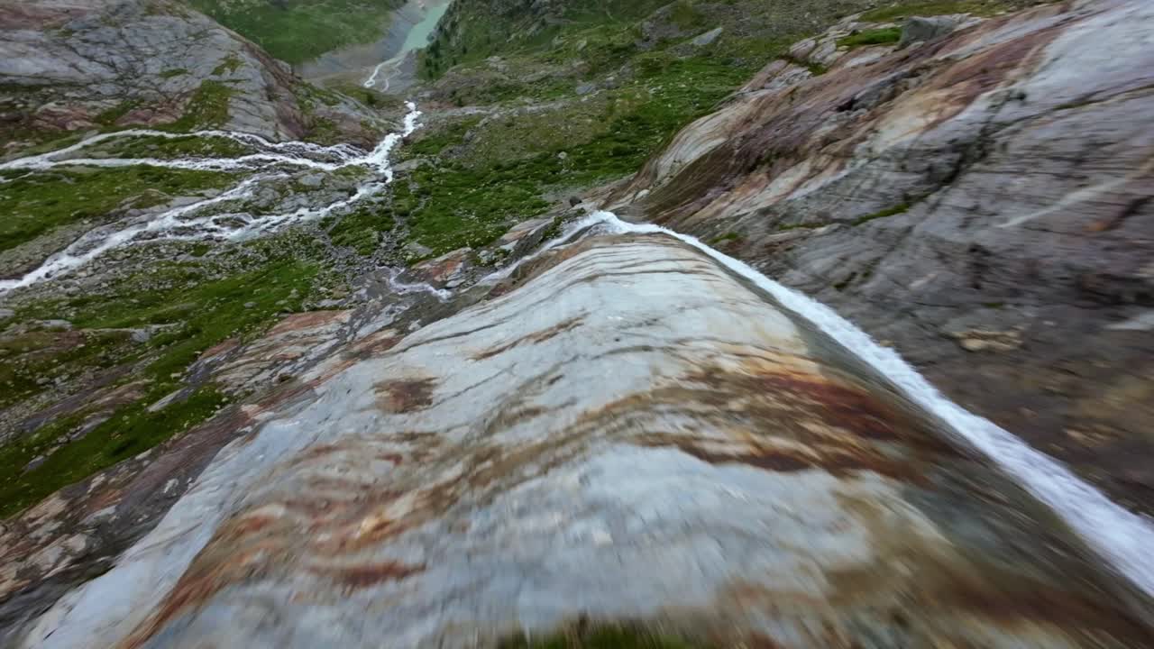 vuelo libre de aviones no tripulados sobre una corriente de agua que fluye en el glaciar fellaria en valmalenco de valtellina, italia