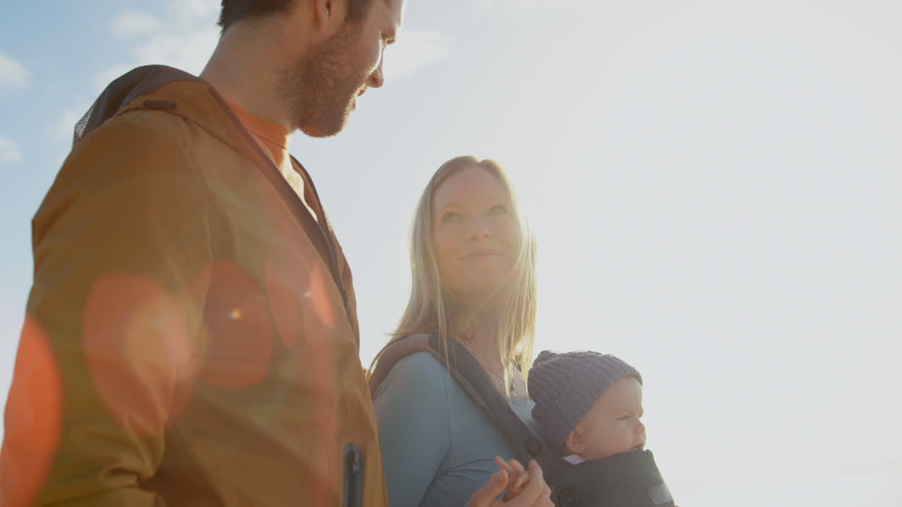 vista de ángulo bajo de la familia caucásica caminando en la playa en un día soleado 4k