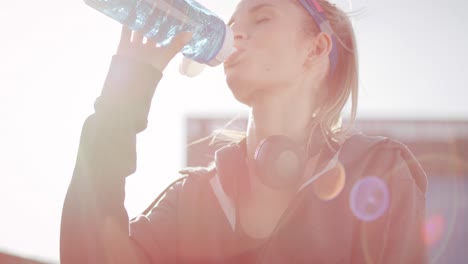 tilt up view of woman drinking water after hard workout