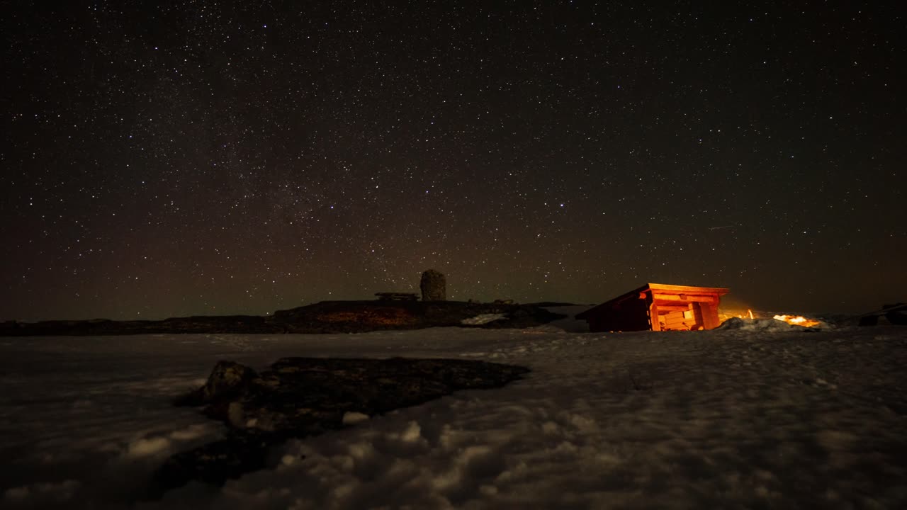 밤하늘의 아름다운 별들과 함께 밤에 모닥불과 오두막